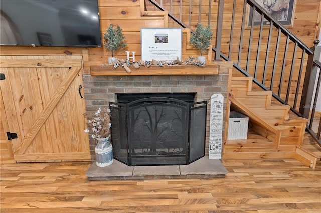 831 SE 11th Pl, Williston, FL 32696 - unfurnished living room with wood finished floors, stairs, a fireplace, and wooden walls