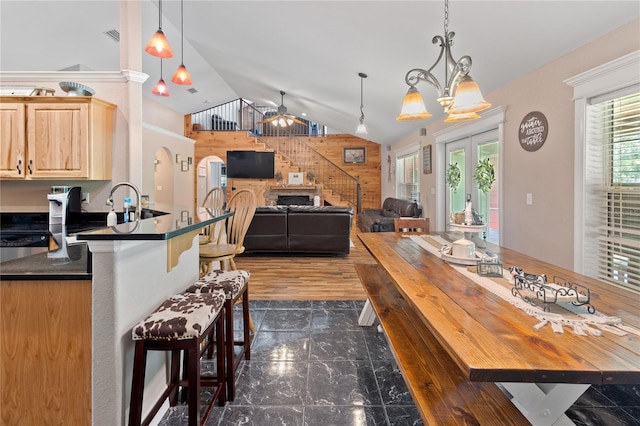 831 SE 11th Pl, Williston, FL 32696 - kitchen with dark countertops, vaulted ceiling, a kitchen bar, wooden walls, and a ceiling fan