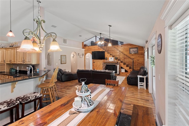 831 SE 11th Pl, Williston, FL 32696 - dining space with wood walls, wood finished floors, lofted ceiling, and stairs