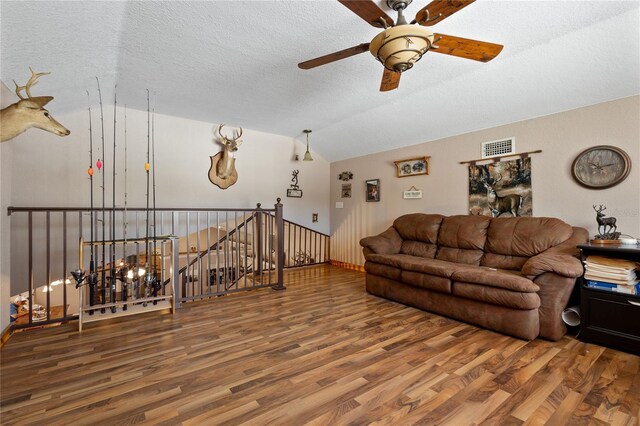 831 SE 11th Pl, Williston, FL 32696 - living room with vaulted ceiling, wood finished floors, a ceiling fan, and a textured ceiling