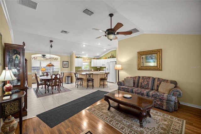 8352 SE 168th Trinity Pl, The Villages, FL 32162 - living area with crown molding, vaulted ceiling, ceiling fan, and light wood finished floors