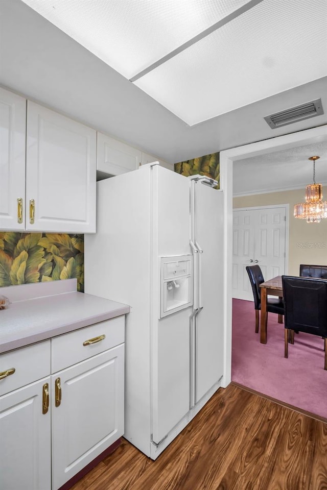 1001 Old Mill Pond Rd, Palm Harbor, FL 34683 - kitchen featuring white fridge with ice dispenser, dark wood-style floors, white cabinets, a chandelier, and light countertops