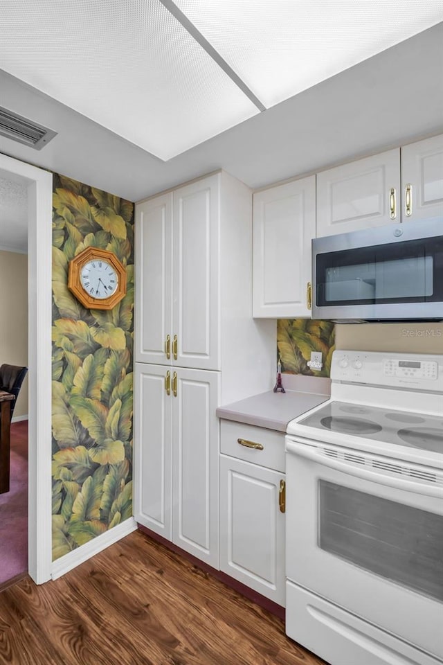 1001 Old Mill Pond Rd, Palm Harbor, FL 34683 - kitchen featuring white range with electric stovetop, stainless steel microwave, dark wood-style flooring, and white cabinets