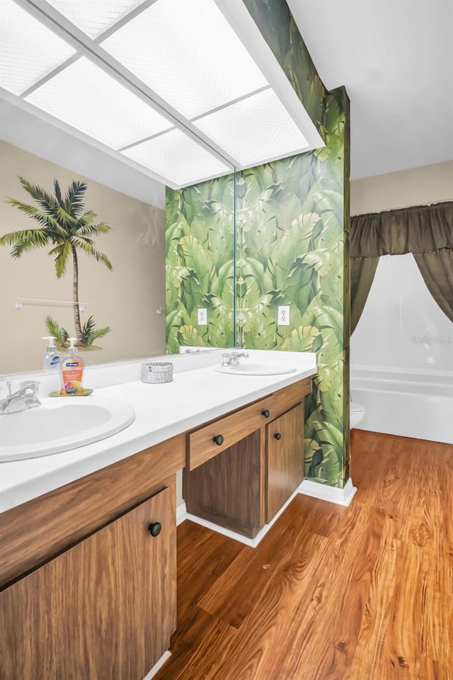 1001 Old Mill Pond Rd, Palm Harbor, FL 34683 - full bathroom featuring wood finished floors, double vanity, and toilet