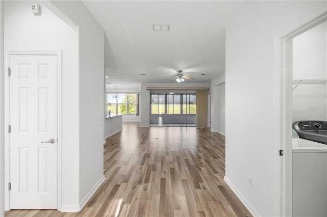 7270 SW 99th Cir, Ocala, FL 34481 - hall featuring washer / dryer, light wood-style floors, and baseboards