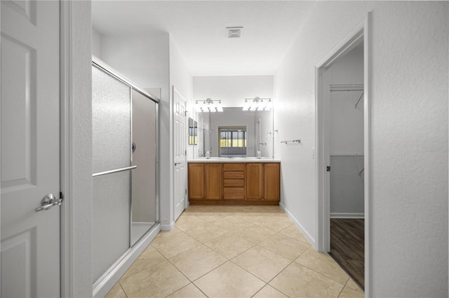 7270 SW 99th Cir, Ocala, FL 34481 - full bath featuring a stall shower, double vanity, a walk in closet, and tile patterned flooring