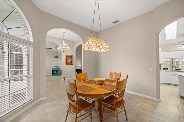 5661 NW 96th Ln, Ocala, FL 34482 - dining area with arched walkways, light tile patterned floors, ceiling fan, baseboards, and a chandelier