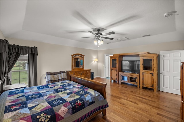 5661 NW 96th Ln, Ocala, FL 34482 - bedroom with wood finished floors, baseboards, a ceiling fan, and a raised ceiling