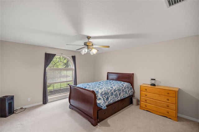 5661 NW 96th Ln, Ocala, FL 34482 - bedroom with light colored carpet, baseboards, a wood stove, and ceiling fan