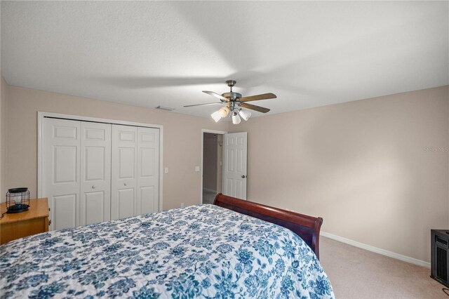 5661 NW 96th Ln, Ocala, FL 34482 - bedroom with light carpet, baseboards, a closet, and a ceiling fan