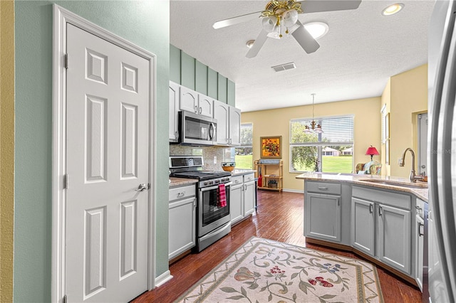 9628 SW 90th St, Ocala, FL 34481 - kitchen with stainless steel appliances, a sink, dark wood-style floors, light countertops, and ceiling fan