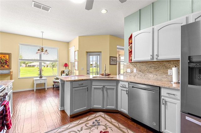 9628 SW 90th St, Ocala, FL 34481 - kitchen with appliances with stainless steel finishes, a sink, a peninsula, dark wood-type flooring, and a ceiling fan