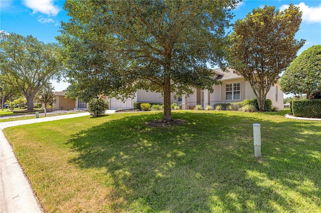9628 SW 90th St, Ocala, FL 34481 - view of property hidden behind natural elements with a front lawn, stucco siding, an attached garage, and concrete driveway