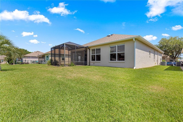 9628 SW 90th St, Ocala, FL 34481 - back of house with a lawn, stucco siding, and glass enclosure