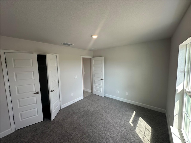 15106 SE 94th Ter, Summerfield, FL 34491 - unfurnished bedroom with dark carpet, multiple windows, a textured ceiling, and baseboards