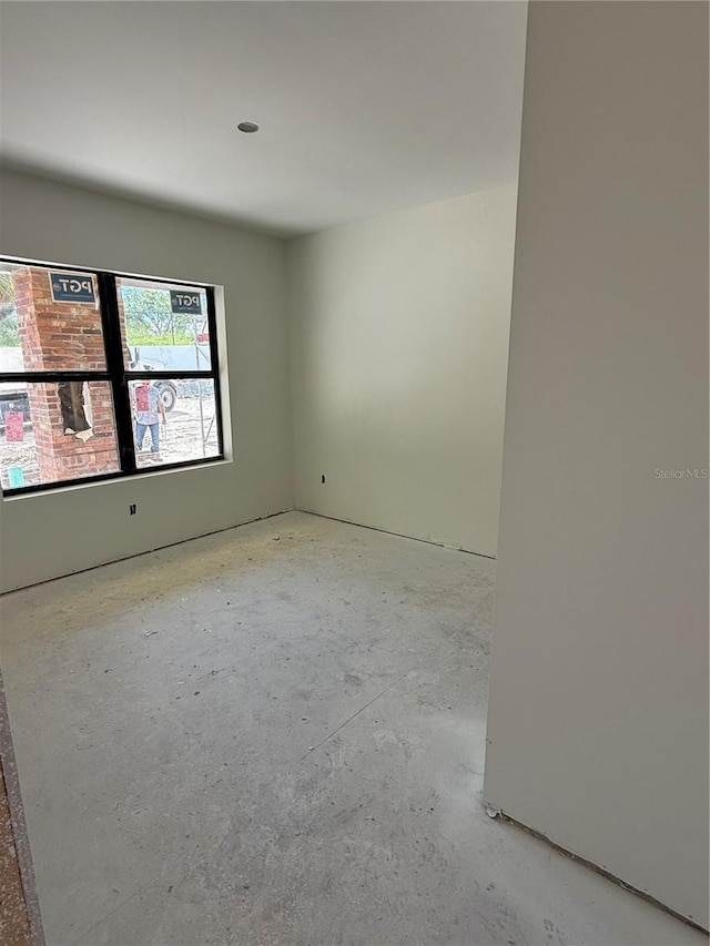 spare room featuring unfinished concrete flooring
