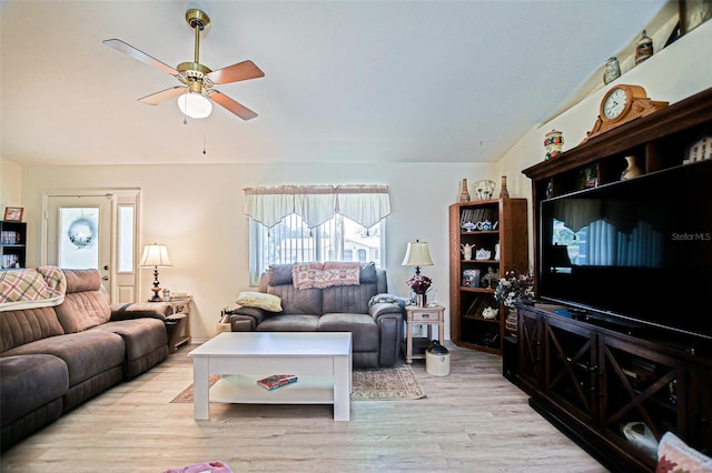 living room with a ceiling fan, lofted ceiling, and light wood-type flooring