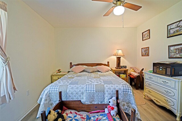 bedroom featuring light wood-style flooring, ceiling fan, and baseboards