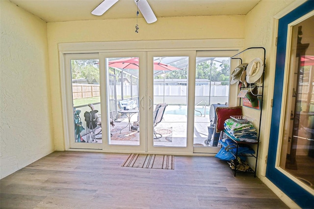 entryway featuring a textured wall, ceiling fan, wood finished floors, and french doors