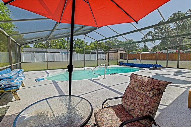 view of swimming pool featuring a fenced backyard, a patio area, and a lanai