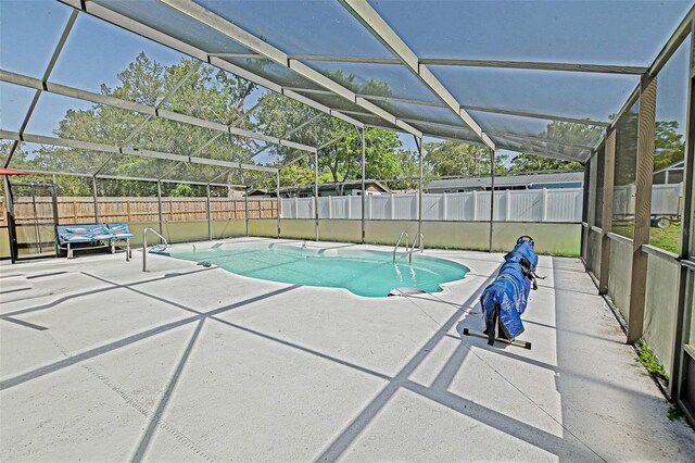view of pool featuring a patio area, a fenced backyard, and glass enclosure