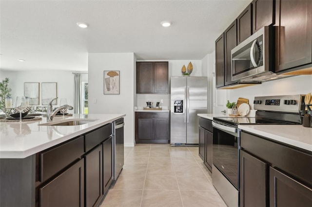 4955 SW 51st Rd, Gainesville, FL 32608 - kitchen featuring stainless steel appliances, a sink, light countertops, dark brown cabinets, and light tile patterned floors