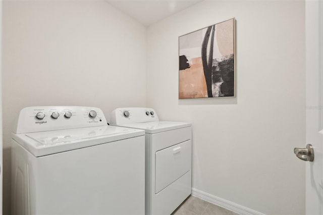 4955 SW 51st Rd, Gainesville, FL 32608 - laundry area featuring washer and dryer, baseboards, and light tile patterned floors