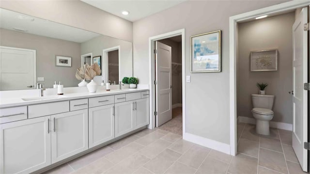 full bath featuring double vanity, tile patterned flooring, baseboards, and toilet
