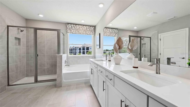 bathroom featuring a stall shower, a bath, double vanity, tile patterned floors, and recessed lighting