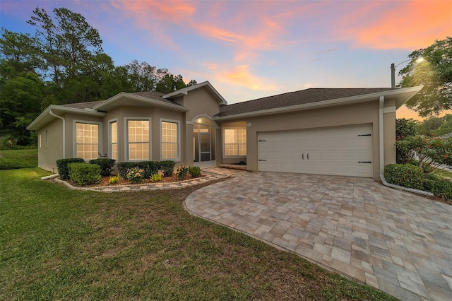 2631 SW 20th Cir, Ocala, FL 34471 - ranch-style house featuring stucco siding, decorative driveway, an attached garage, and a yard