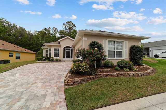 2631 SW 20th Cir, Ocala, FL 34471 - view of front of property with a front yard, stucco siding, and decorative driveway