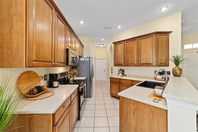 2631 SW 20th Cir, Ocala, FL 34471 - kitchen featuring a sink, appliances with stainless steel finishes, a peninsula, brown cabinetry, and recessed lighting