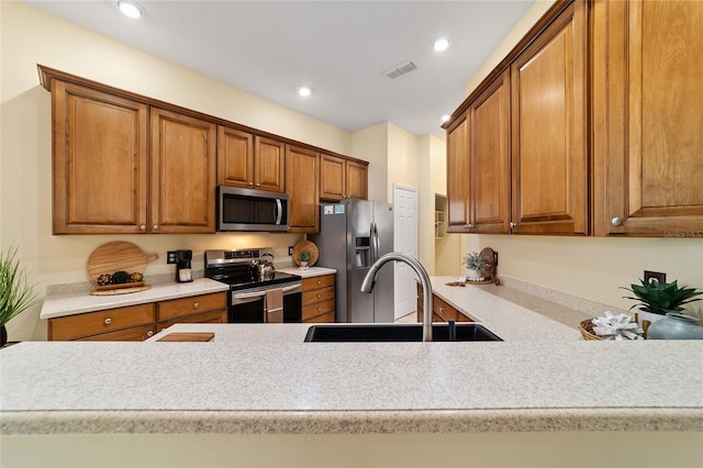 2631 SW 20th Cir, Ocala, FL 34471 - kitchen with stainless steel appliances, a sink, brown cabinets, light countertops, and recessed lighting