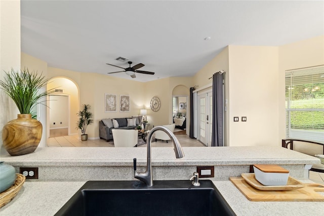 2631 SW 20th Cir, Ocala, FL 34471 - kitchen with arched walkways, a sink, ceiling fan, and light tile patterned floors