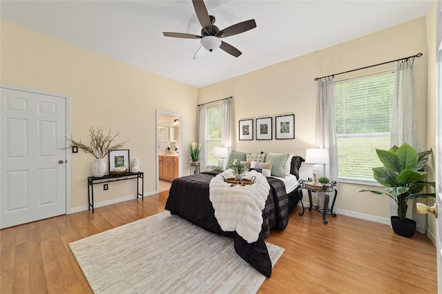 2631 SW 20th Cir, Ocala, FL 34471 - bedroom with light wood-style floors, baseboards, ceiling fan, and ensuite bathroom
