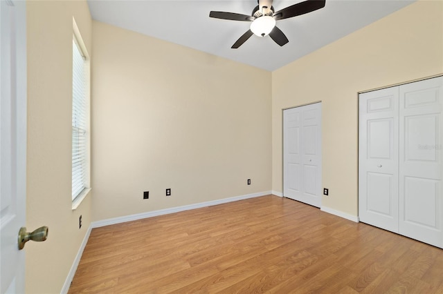 2631 SW 20th Cir, Ocala, FL 34471 - unfurnished bedroom with two closets, light wood-type flooring, multiple windows, and baseboards