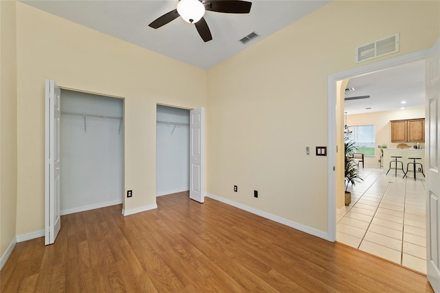 2631 SW 20th Cir, Ocala, FL 34471 - unfurnished bedroom featuring two closets, light wood-type flooring, a ceiling fan, and baseboards