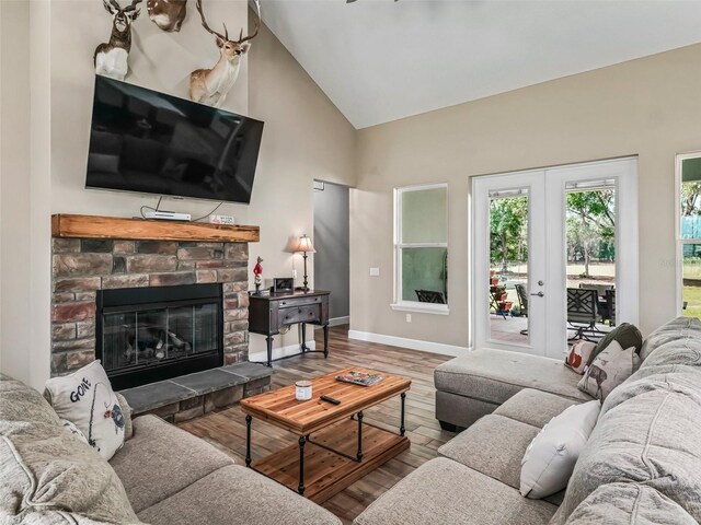 5330 NE 111th Lane Rd, Anthony, FL 32617 - living area with high vaulted ceiling, wood finished floors, a stone fireplace, baseboards, and french doors