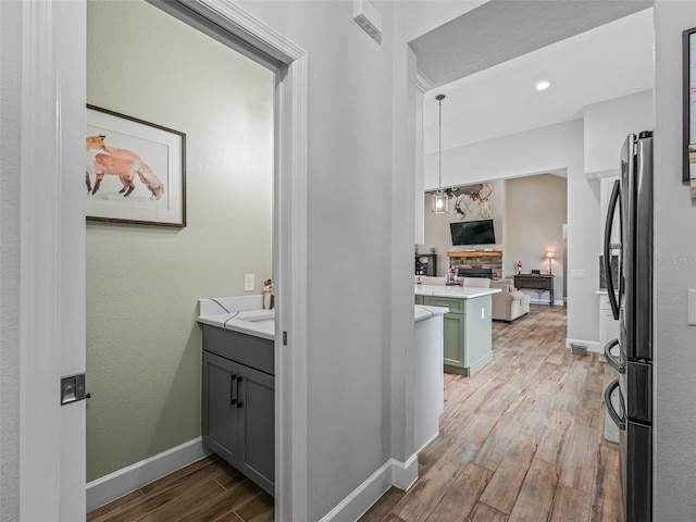 5330 NE 111th Lane Rd, Anthony, FL 32617 - bathroom featuring wood finished floors, baseboards, a fireplace, and vanity