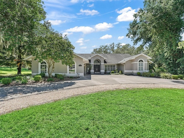 5714 NW 80th Avenue Rd, Ocala, FL 34482 - ranch-style home featuring stucco siding, a front lawn, and driveway
