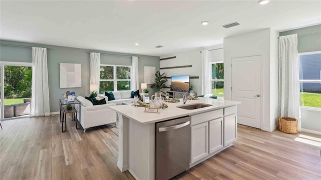 8647 SW 44th Ter, Ocala, FL 34476 - kitchen with stainless steel dishwasher, a sink, open floor plan, light countertops, and light wood-style flooring