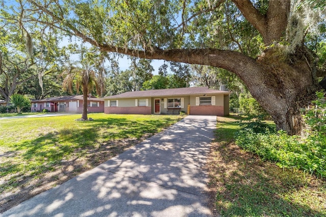 6060 SE 119th Pl, Belleview, FL 34420 - ranch-style house with concrete driveway and a front lawn