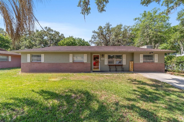 6060 SE 119th Pl, Belleview, FL 34420 - ranch-style home with brick siding, stucco siding, and a front yard