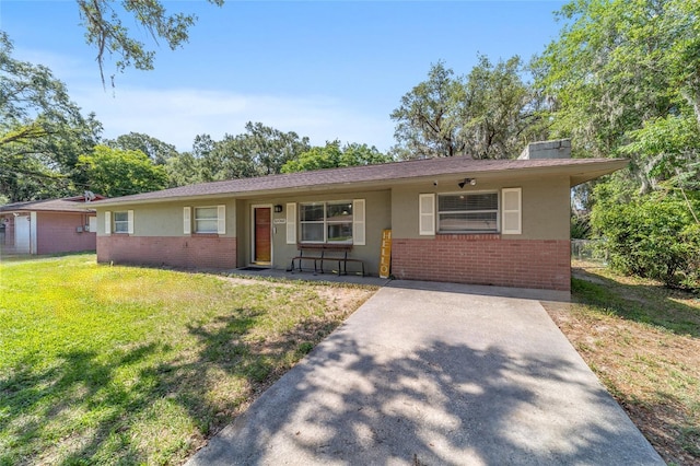 6060 SE 119th Pl, Belleview, FL 34420 - single story home with brick siding, a front lawn, covered porch, a chimney, and stucco siding
