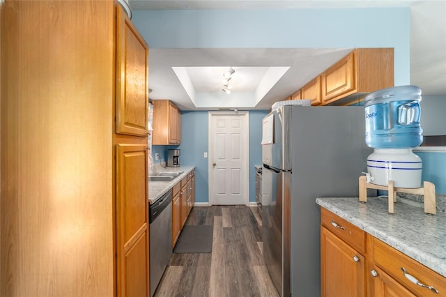 6060 SE 119th Pl, Belleview, FL 34420 - kitchen featuring stainless steel appliances, a tray ceiling, dark wood-style flooring, brown cabinets, and a sink