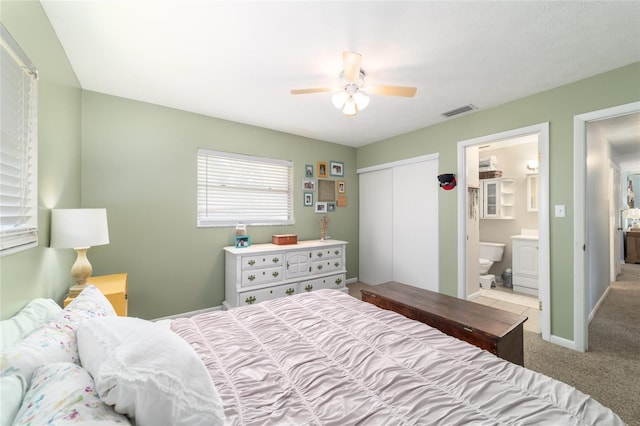 6060 SE 119th Pl, Belleview, FL 34420 - bedroom featuring carpet flooring, a closet, ensuite bath, and a ceiling fan