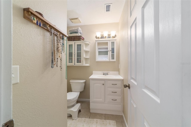 6060 SE 119th Pl, Belleview, FL 34420 - bathroom with vanity, toilet, tile patterned flooring, and a textured wall