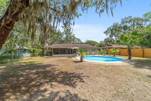 6060 SE 119th Pl, Belleview, FL 34420 - view of pool with a sunroom and a fenced backyard