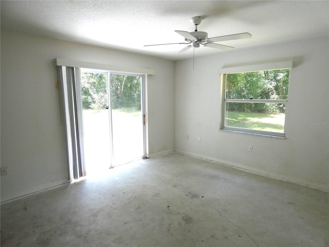19026 SW 100th Pl, Dunnellon, FL 34432 - spare room with unfinished concrete floors, a ceiling fan, and baseboards