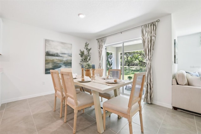 dining space featuring baseboards and light tile patterned floors